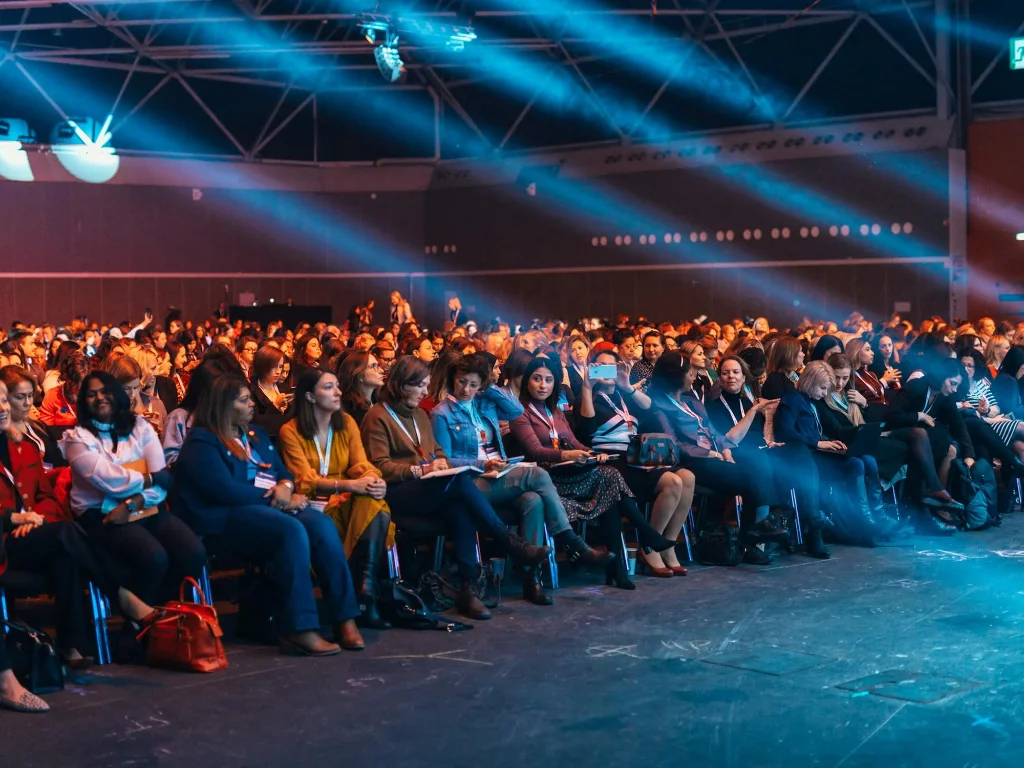 Attendees seated in a packed conference auditorium
